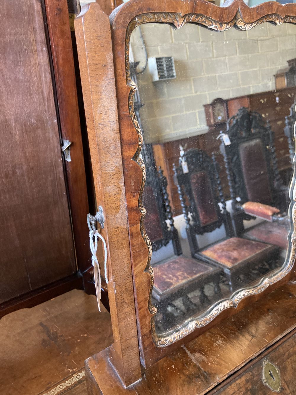An early 18th century walnut toilet mirror, the base enclosed by fall front over drawer, width 46cm, depth 30cm, height 74cm